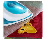 Applying custom iron-on patch with heat press on fabric, showing strong adhesive bond — perfect for jackets, caps, and uniforms by Embrolab.