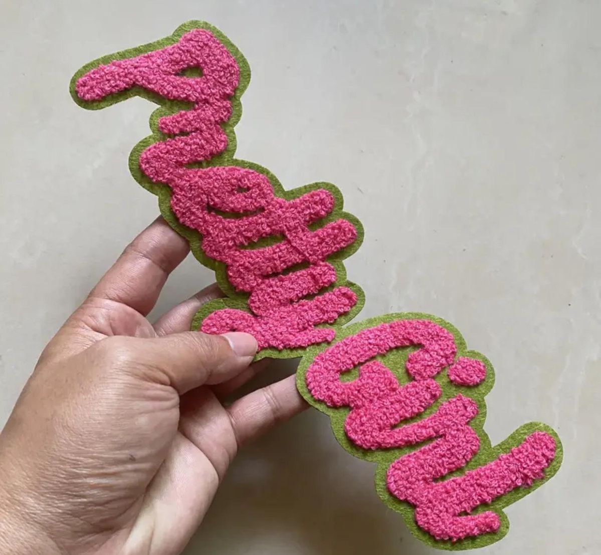 Pink and green chenille script patch with textured yarn, ideal for custom varsity jackets or wholesale chenille patches.