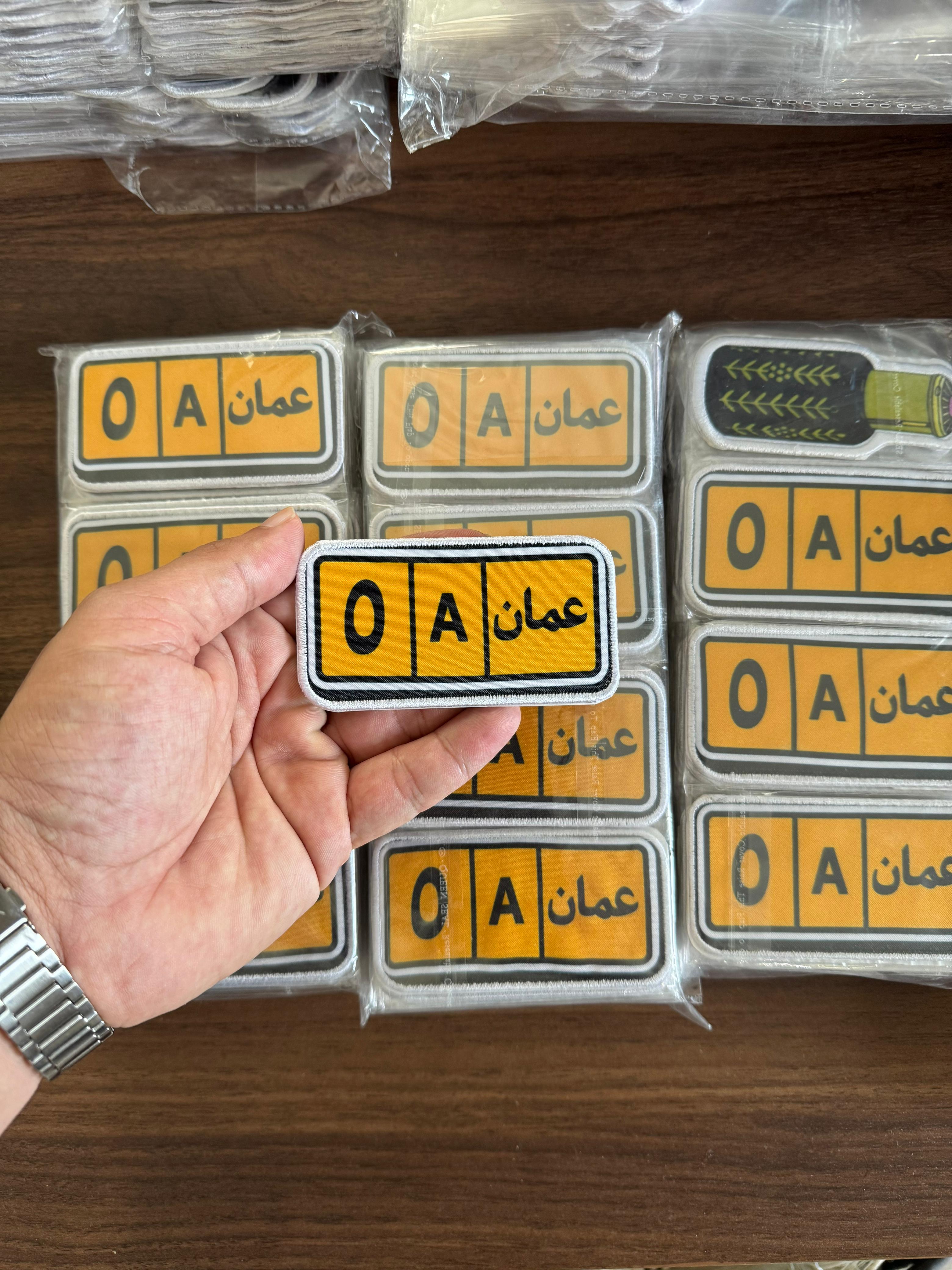 Custom printed fabric patch with oman text in Arabic and English, designed for Oman uniforms and identification use.
