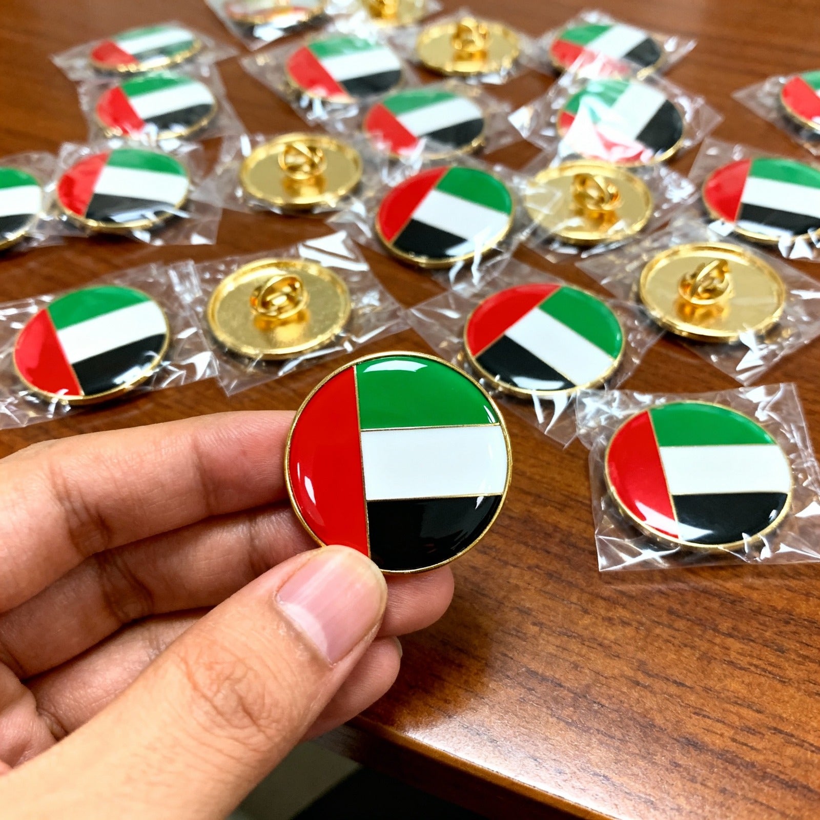 Close-up of a custom UAE flag enamel pin badge with gold finish and butterfly clutch backing, high-quality lapel pin for uniforms and events, Embrolab custom pin badges UAE.