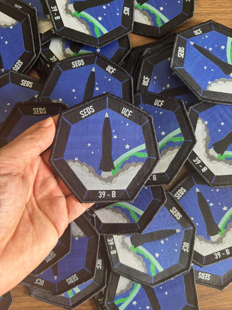 Blue and black woven patch showing rocket launch artwork for SEDS UCF, crafted as a durable woven fabric label ideal for sew-on patches or Velcro applications.