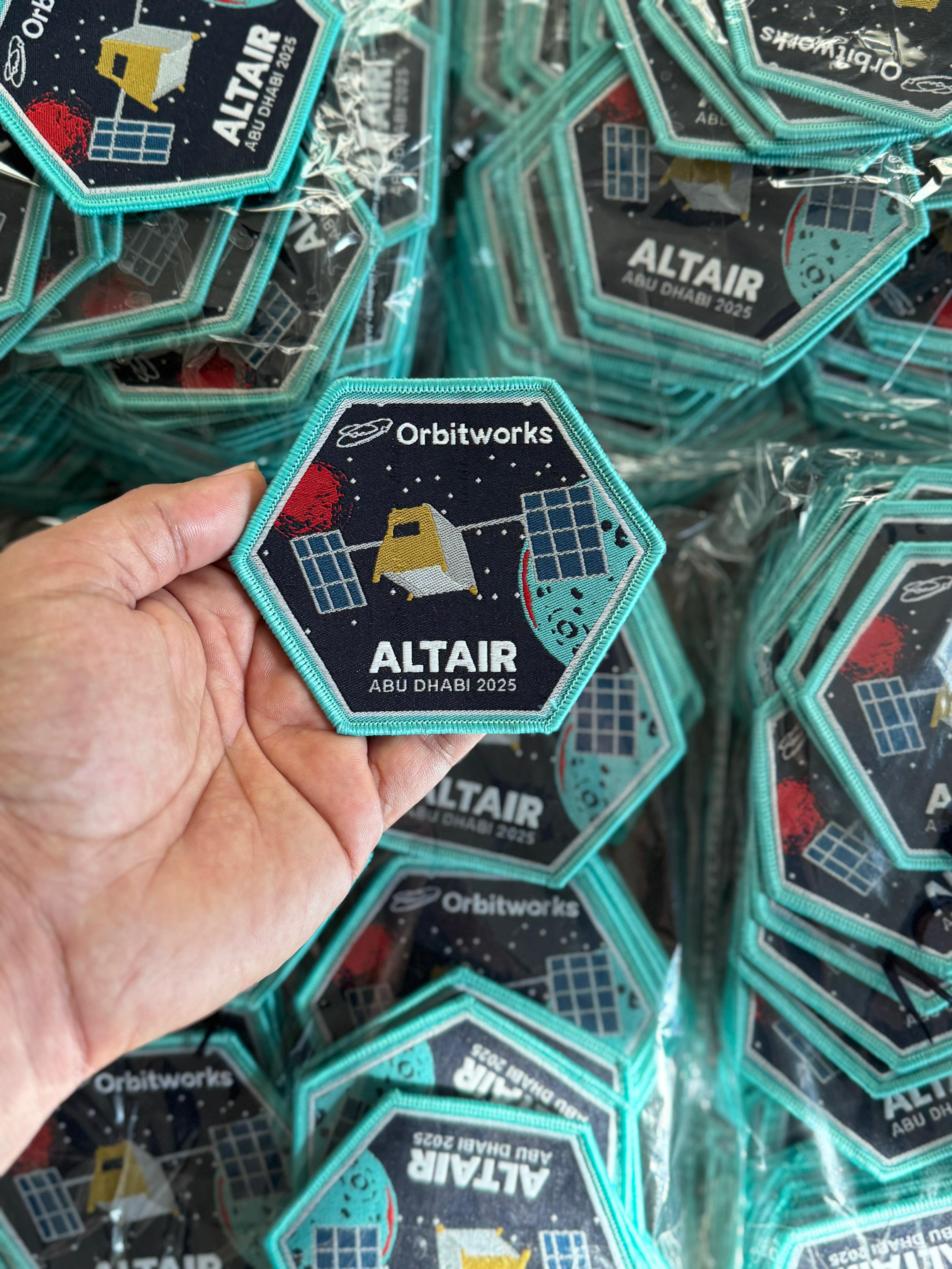 High-quality custom woven patch with Orbitworks Altair Abu Dhabi 2025 design, made from durable woven fabric and finished with teal edging — perfect for sew-on or Velcro use.