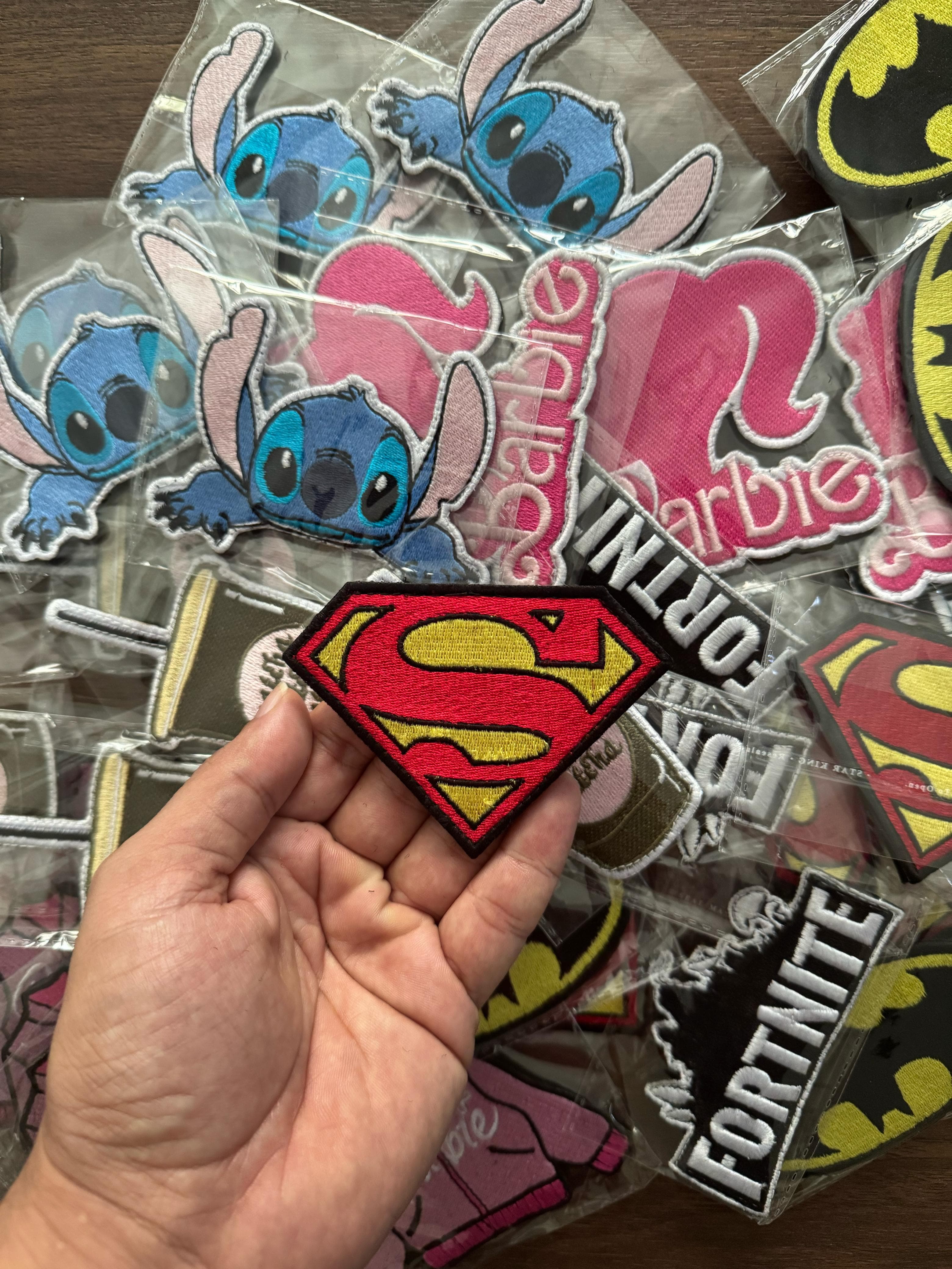 High-quality iron-on Superman logo patch in red and yellow embroidery, ideal for jackets and bags