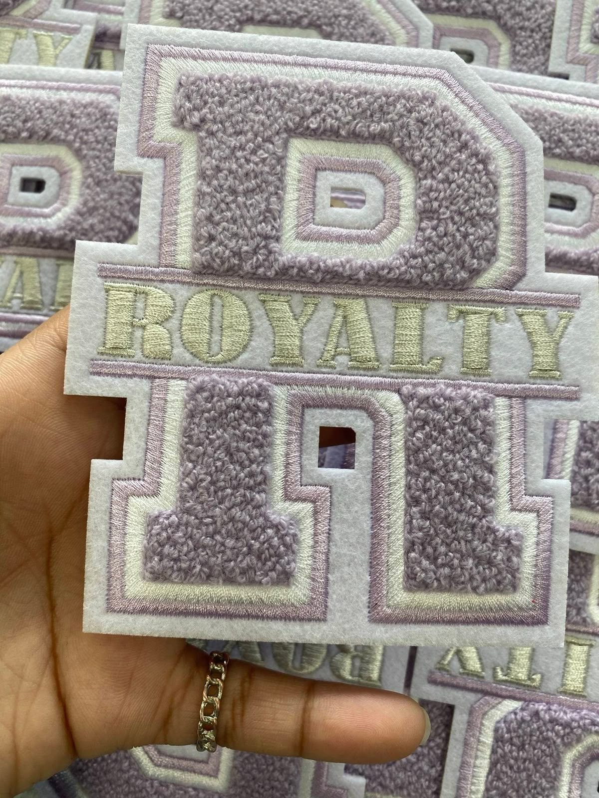 oft lilac custom chenille patch featuring letter R and the word Royalty, ideal for varsity jacket patches and chenille letters.