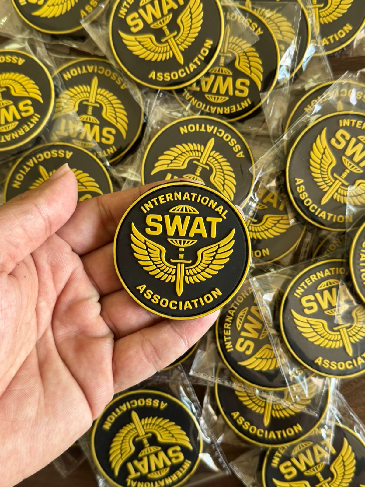 High-quality round custom PVC patch with embossed SWAT Association logo in yellow and black rubber, ideal for tactical use.
